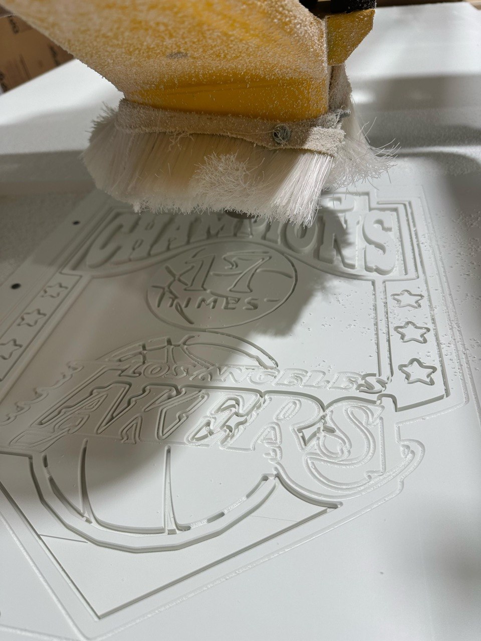 Brushing dust off a freshly CNC carved Lakers plaque