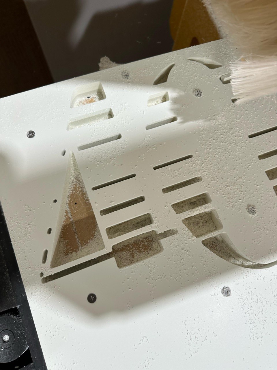 CNC routed lettering panel with dust being brushed off