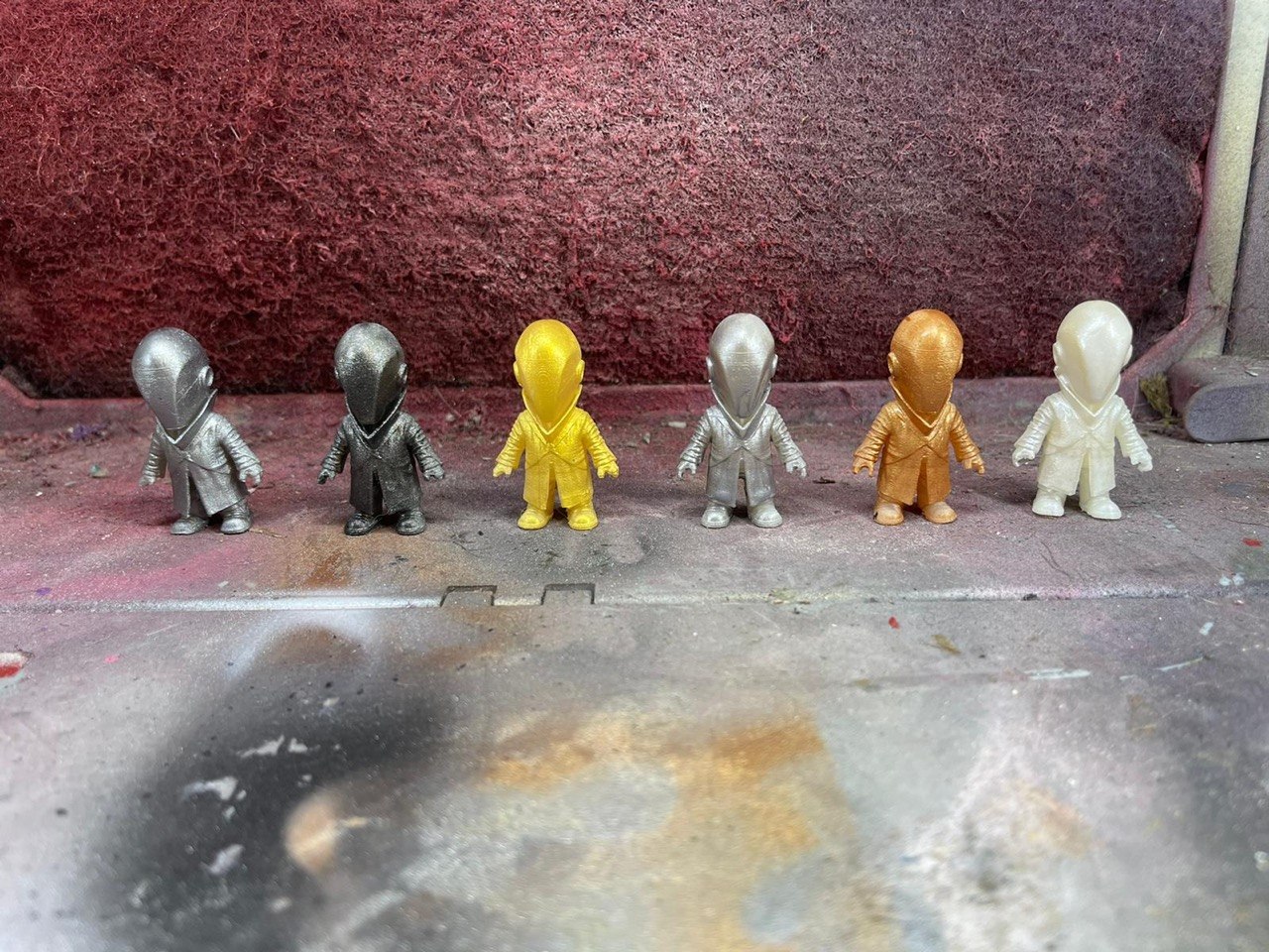 Set of six small hooded figurines finished in metallic gold, silver and bronze