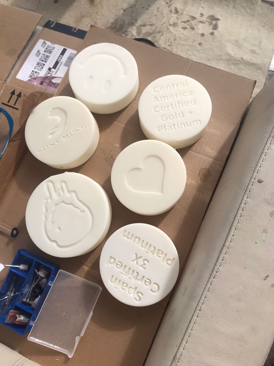 Five white resin embossing dies including a record label logo