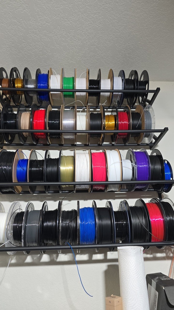 Wall rack holding around forty spools of 3D printing filament