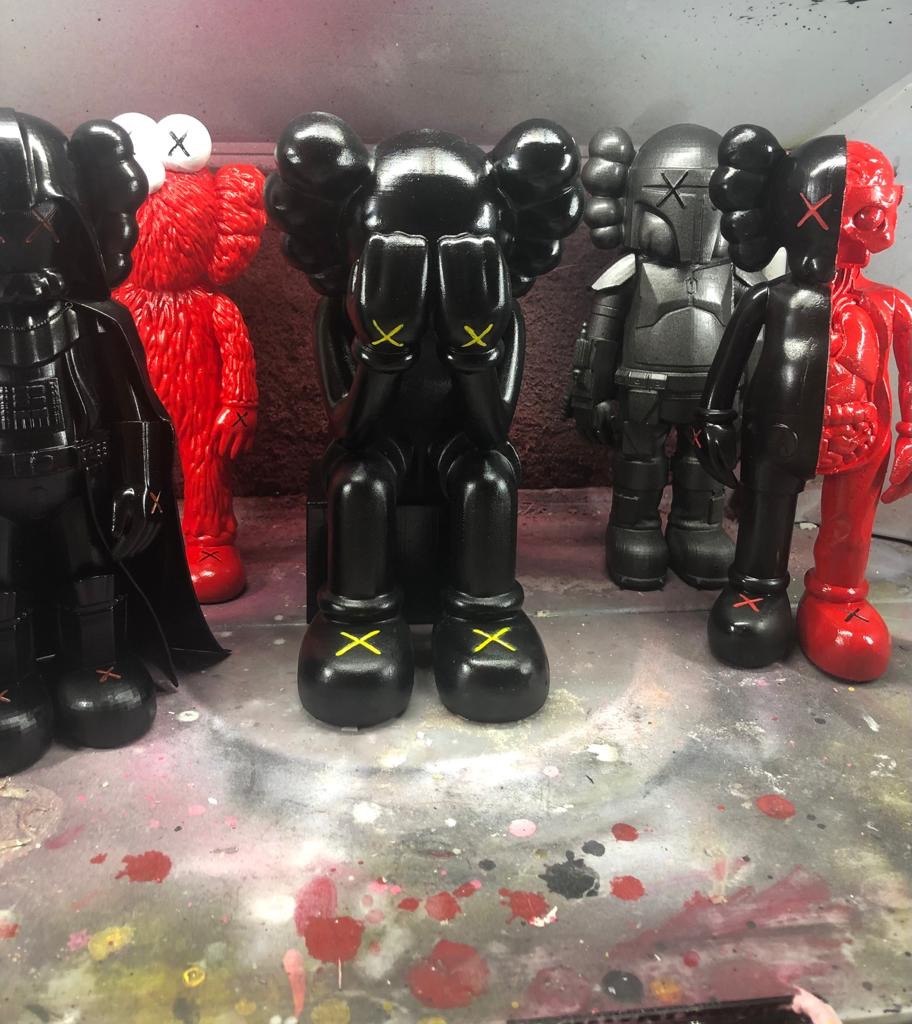 Row of hand-painted collectible art figures in black, red and gray
