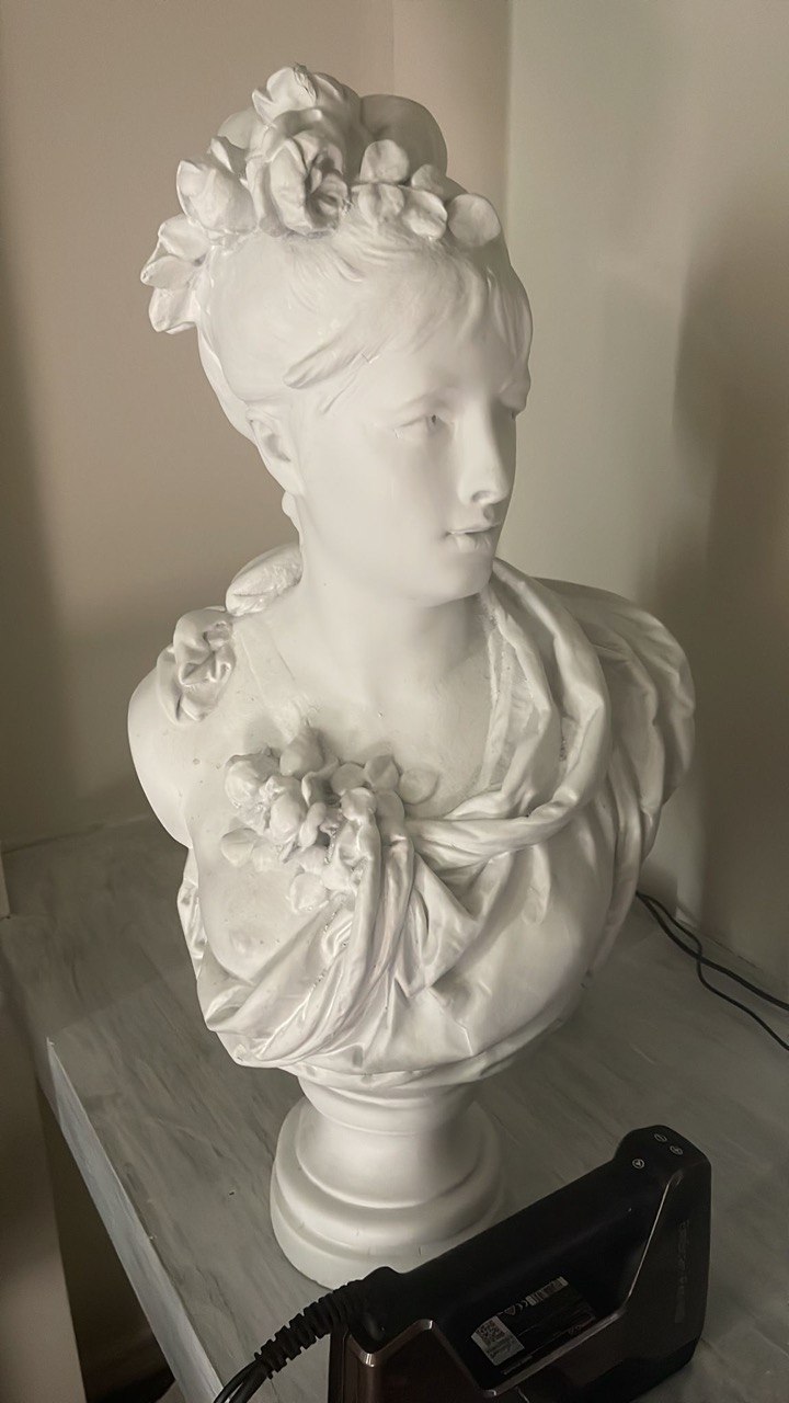 Handheld 3D scanner capturing a classical sculpture bust