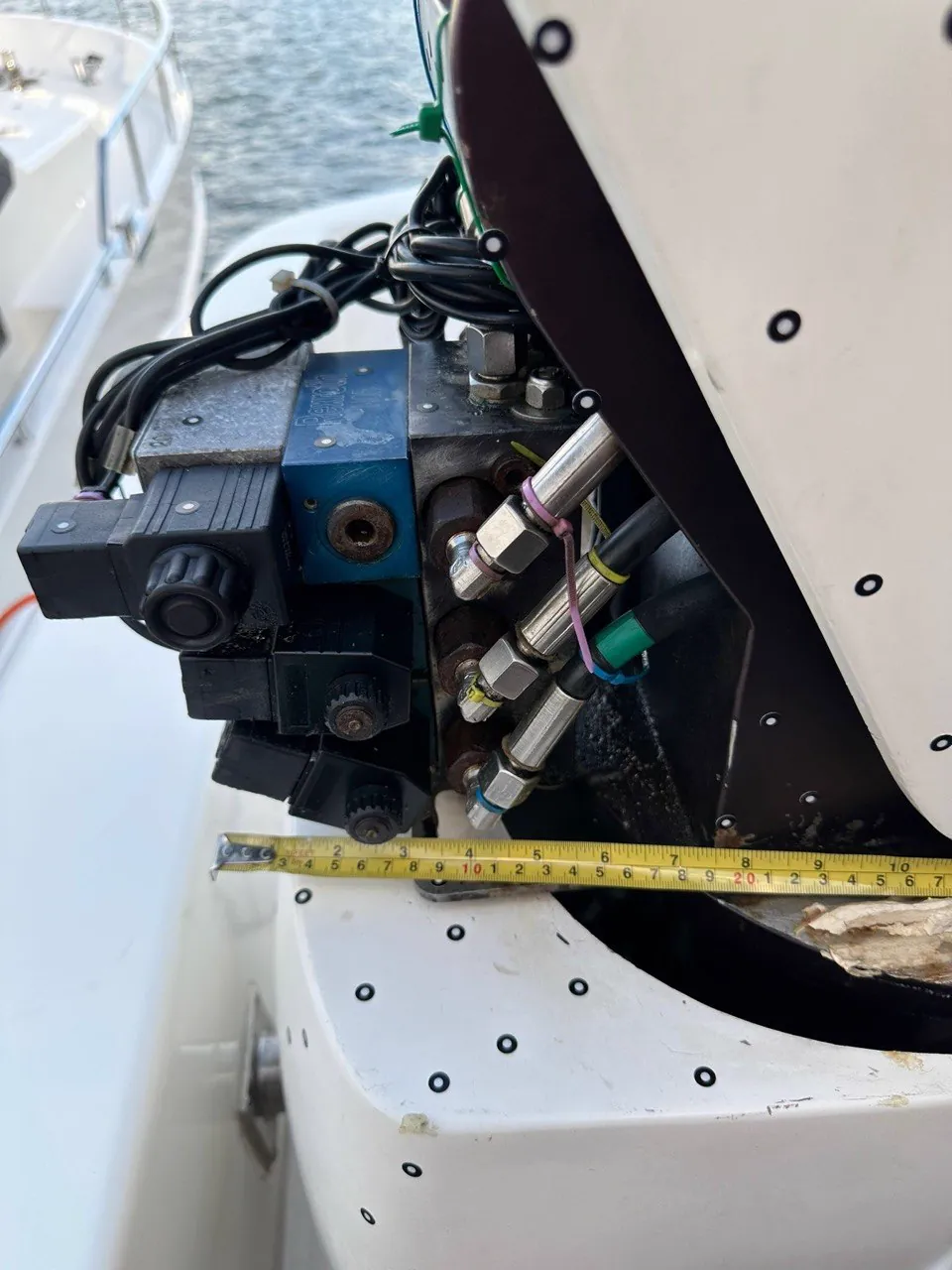 Tape measure spanning a boat hydraulic valve compartment