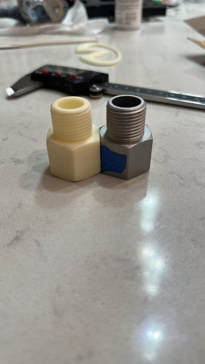 Original steel pipe fitting beside a 3D printed nylon replacement