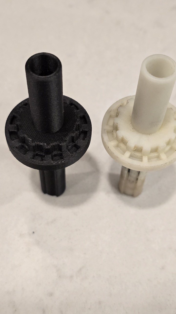 Worn OEM splined shaft next to a reverse engineered black replacement